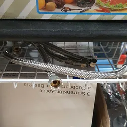 Buisleiding en flexibele slangen met koppelingen onder een zwarte opbouw
