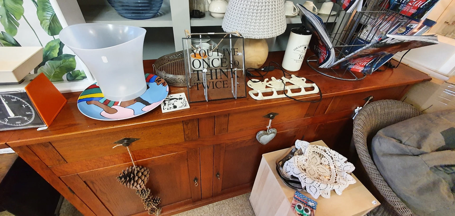 Houten dressoir met diverse huishoudelijke artikelen en decoratieve spullen uitgestald