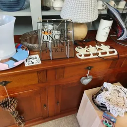 Houten dressoir met diverse huishoudelijke artikelen en decoratieve spullen uitgestald