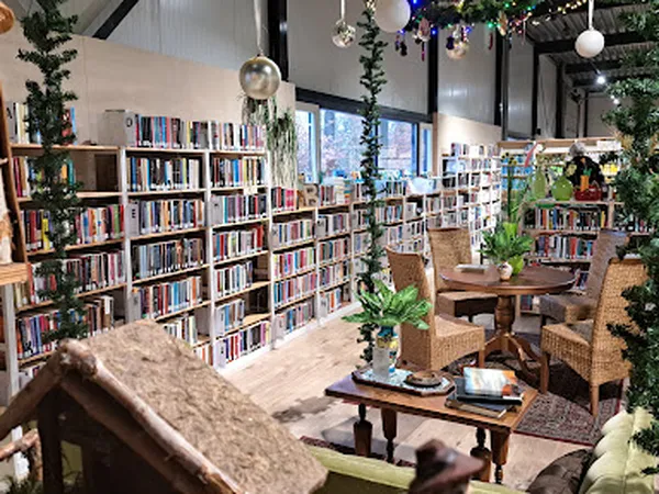 Bibliotheekruimte met boekenkasten, leeshoeken, groene planten en decoratieve elementen