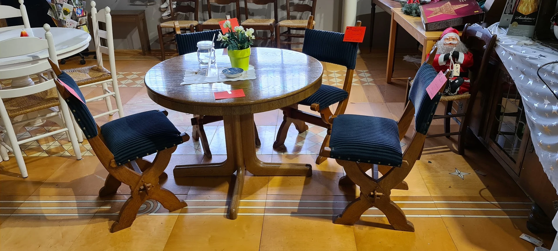 Ronde houten eettafel met vier stoelen met donkerblauwe zitting