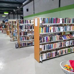 Boekenrekken met dvd's en cd's in de kringloopwinkel, met houten kasten en witte scheidingswanden