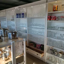 Glazen vitrinekasten met diverse glaswerk en serviesgoed in een kringloopwinkel