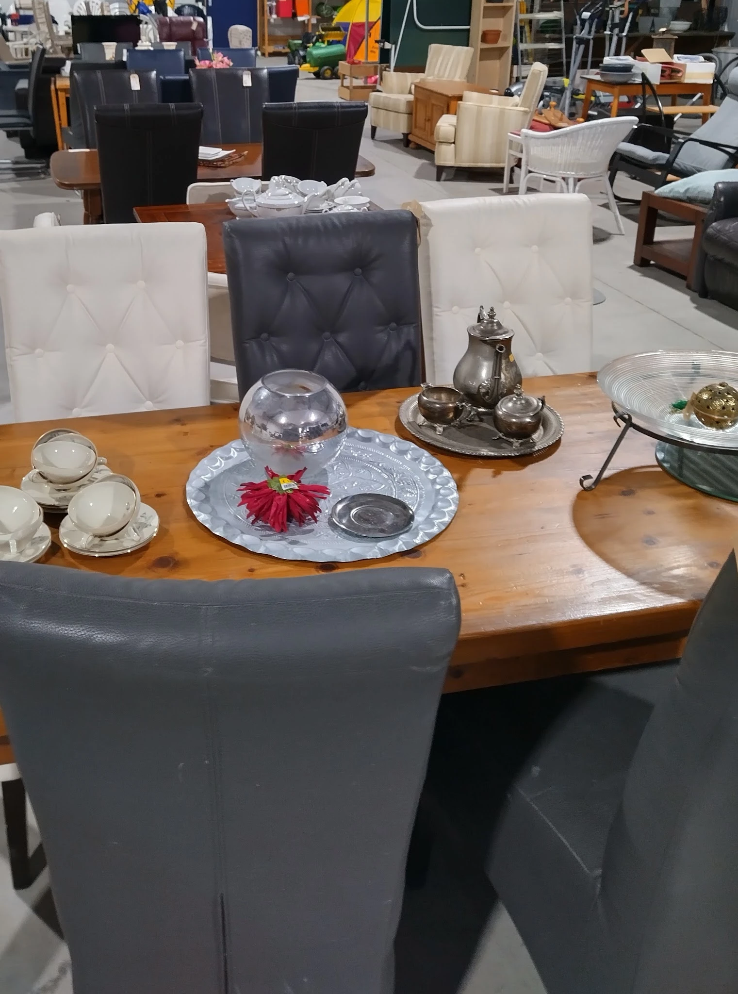 Houten tafel gedekt met servies, zilveren theeservies en decoratieve items