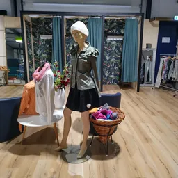 Etalage met kledingmanequin in zwart-wit outfit en mand met gekleurde kleding