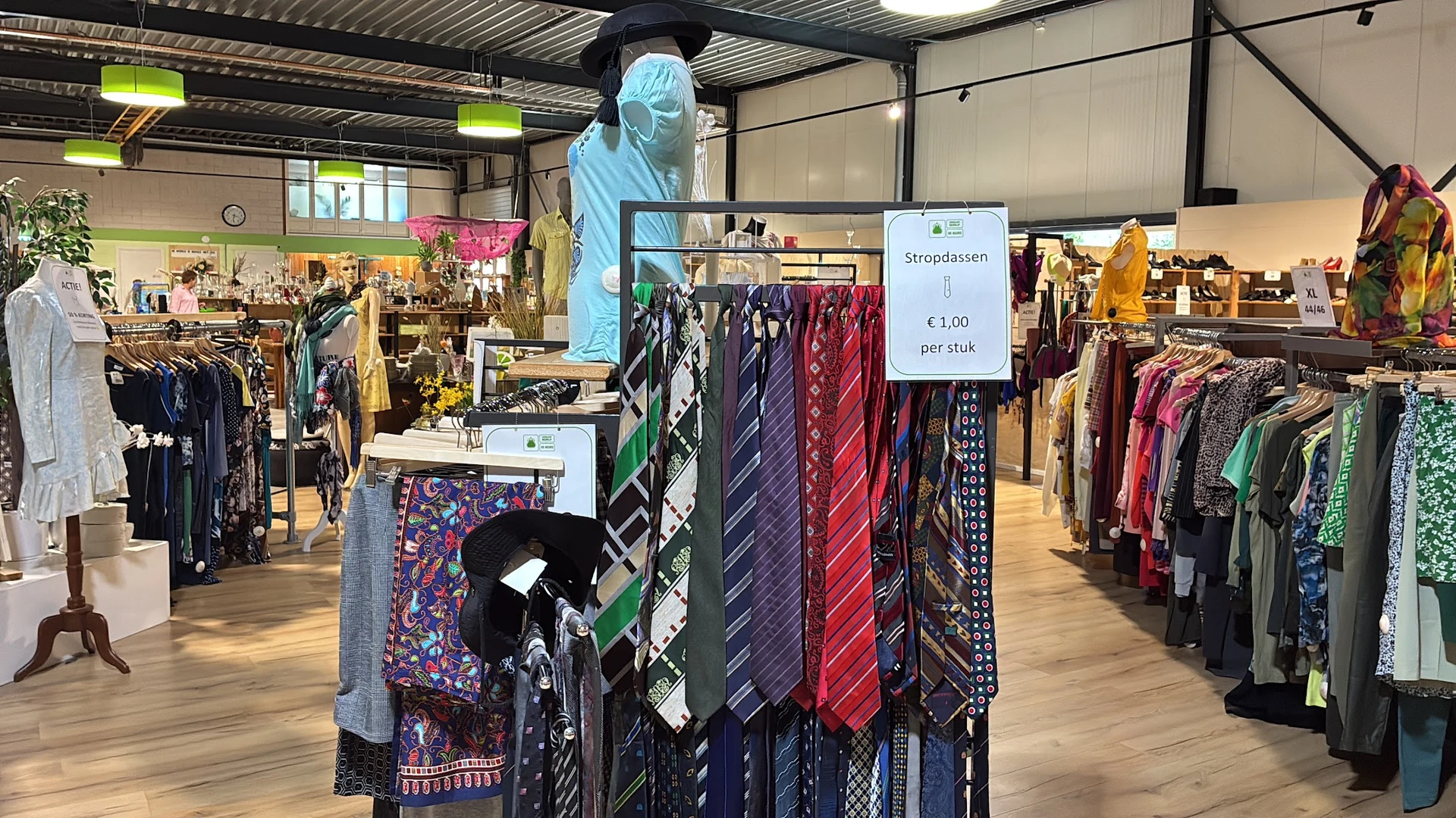 Rekken met stropdassen en sjaals, waaronder een display met prijskaart van €1,00