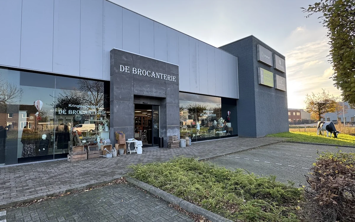 Moderne gevel van kringloopwinkel De Brocanterie met donkerblauwe afwerking en glazen ingang aan de Horsterweg