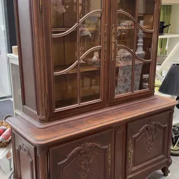 Antieke houten vitrinekast met glazen deuren en houtsnijwerk, tweedehands meubel in kringloopwinkel