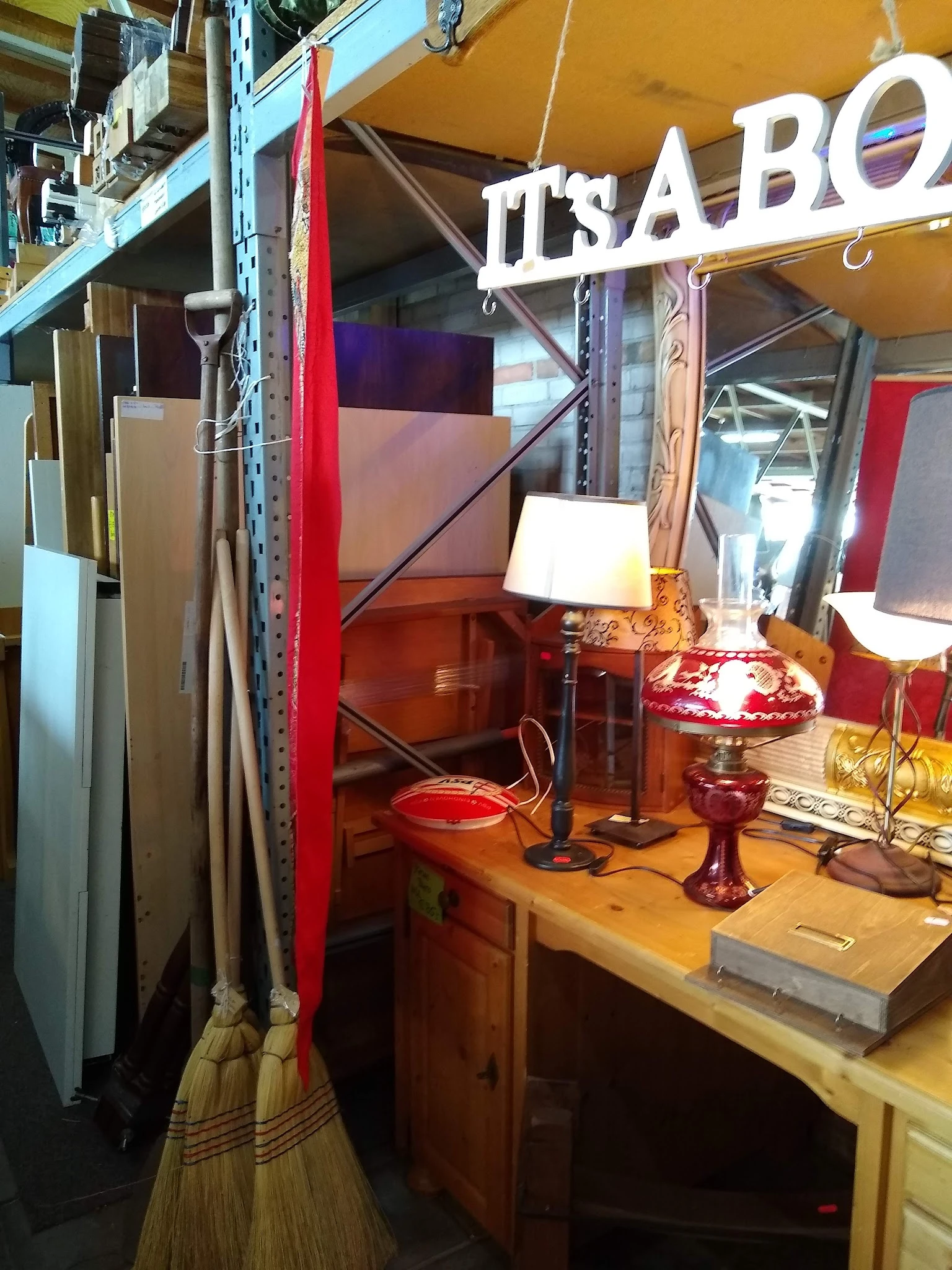 Rode vintage lampen en decoratieve items op een houten tafel in een kringloopwinkel