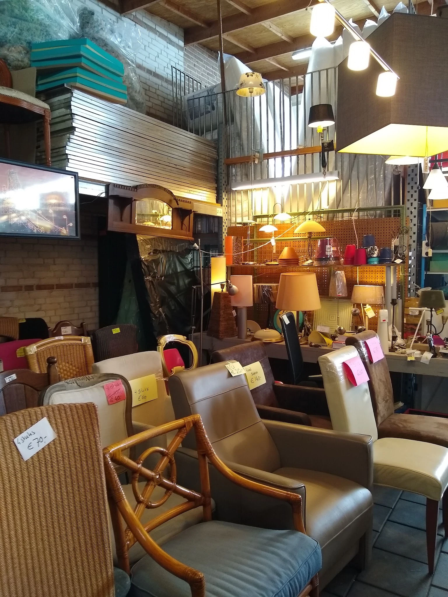 Winkelvloer met uitgestalde meubels, stoelen, lampen en huishoudelijke artikelen in een kringloopwinkel