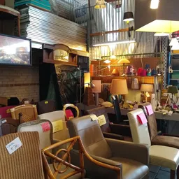 Winkelvloer met uitgestalde meubels, stoelen, lampen en huishoudelijke artikelen in een kringloopwinkel