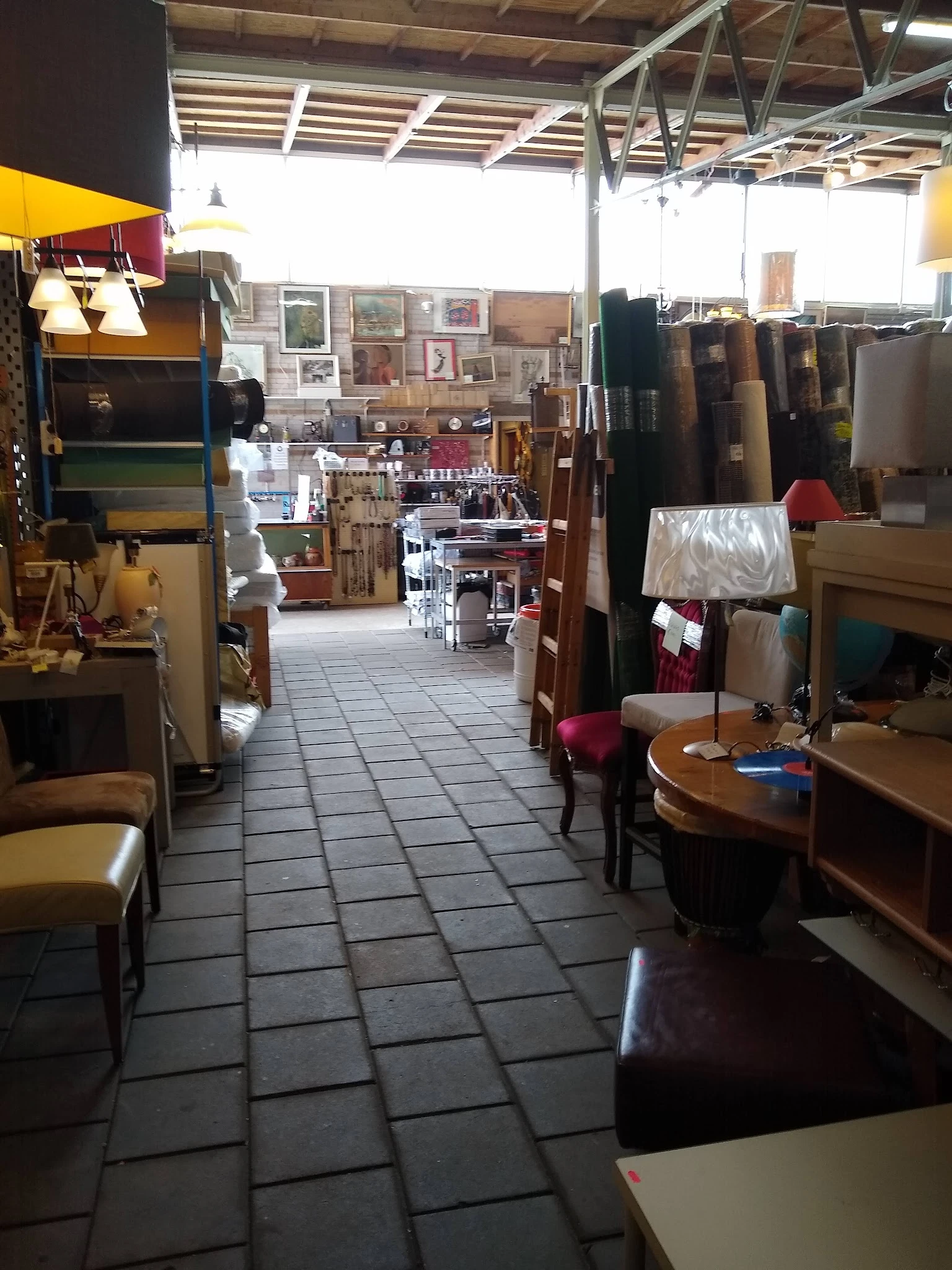Winkelinterieur met houten meubels, stellingen met spullen en decoraties langs de wanden