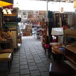 Winkelinterieur met houten meubels, stellingen met spullen en decoraties langs de wanden
