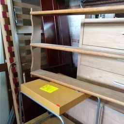 Houten wandplank met twee niveaus, geel doosje erop, tegen witte kastenwand.