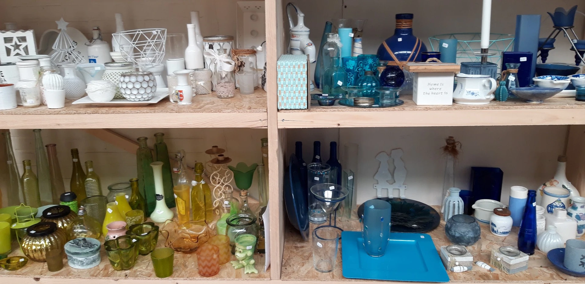 Kast met gesorteerde huishoudartikelen: glazen flesjes, cosmeticaproducten, blauwe decoratievoorwerpen en diverse voorraden o