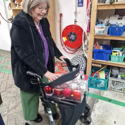 Vrijwilliger werkt aan een kinderwagen in de werkplaats van de kringloopwinkel