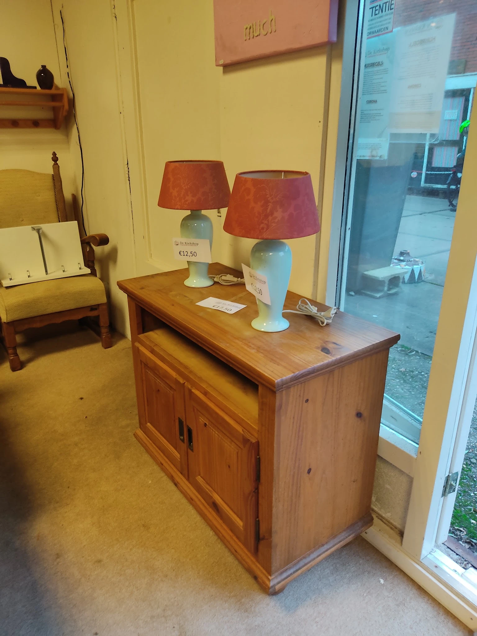 Houten dressoir met twee blauwe tafellampen met rode kappen in een kringloopwinkel