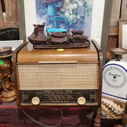 Vintage houten radio met tweedehands decoratieve objecten erop