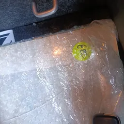 Ingepakt artikel in bubbeltjesplastic met geel en wit etiket