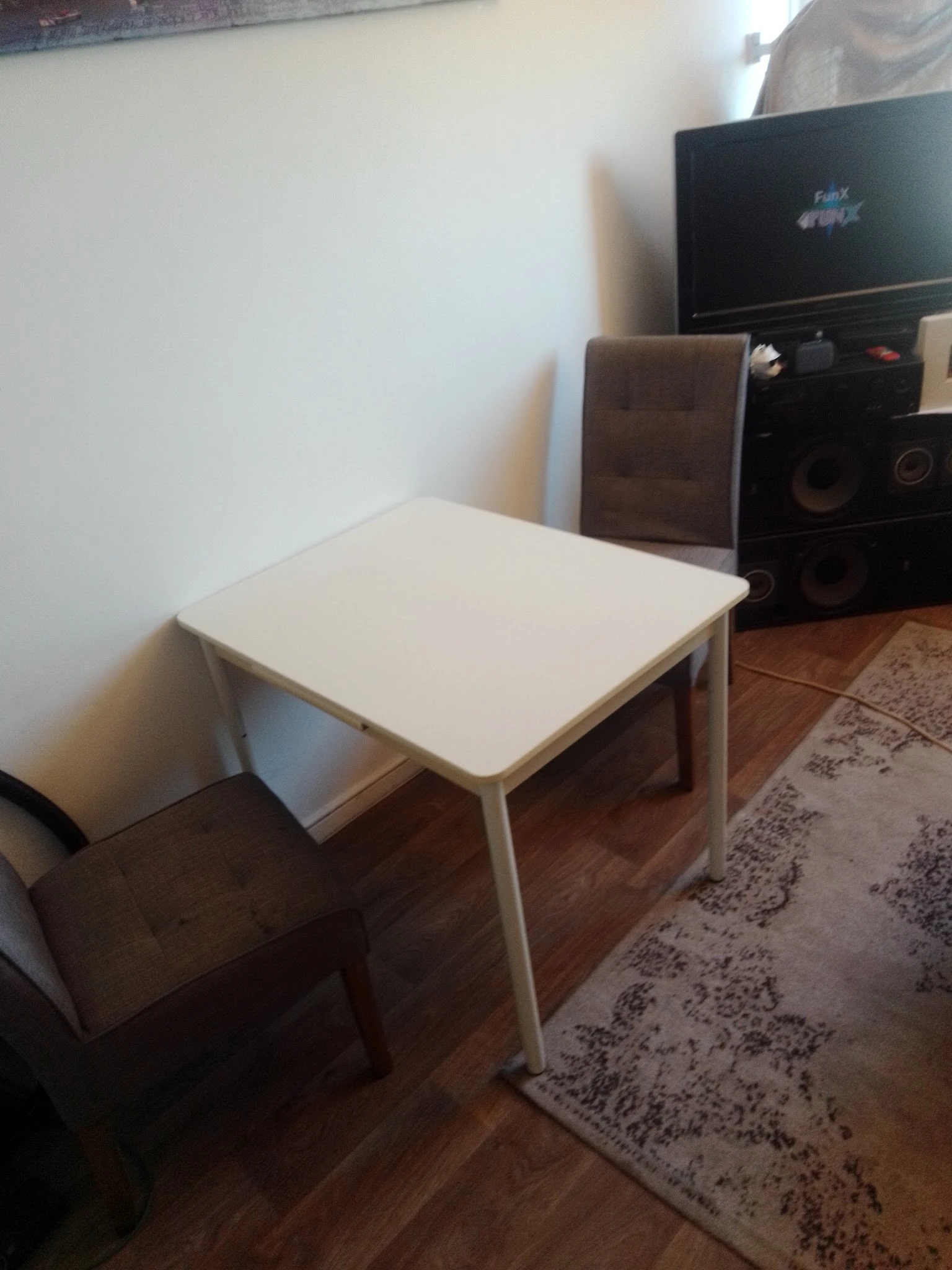 Witte rechthoekige tafel met metalen poten op houten vloer