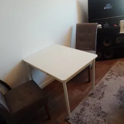 Witte rechthoekige tafel met metalen poten op houten vloer