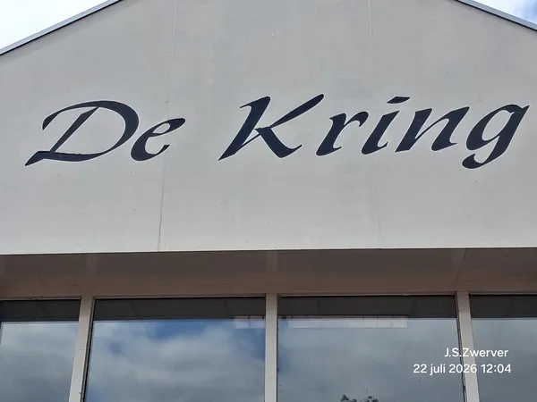 Gevel van kringloopwinkel met 'De Kring' naam en ramen