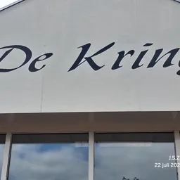 Gevel van kringloopwinkel met 'De Kring' naam en ramen