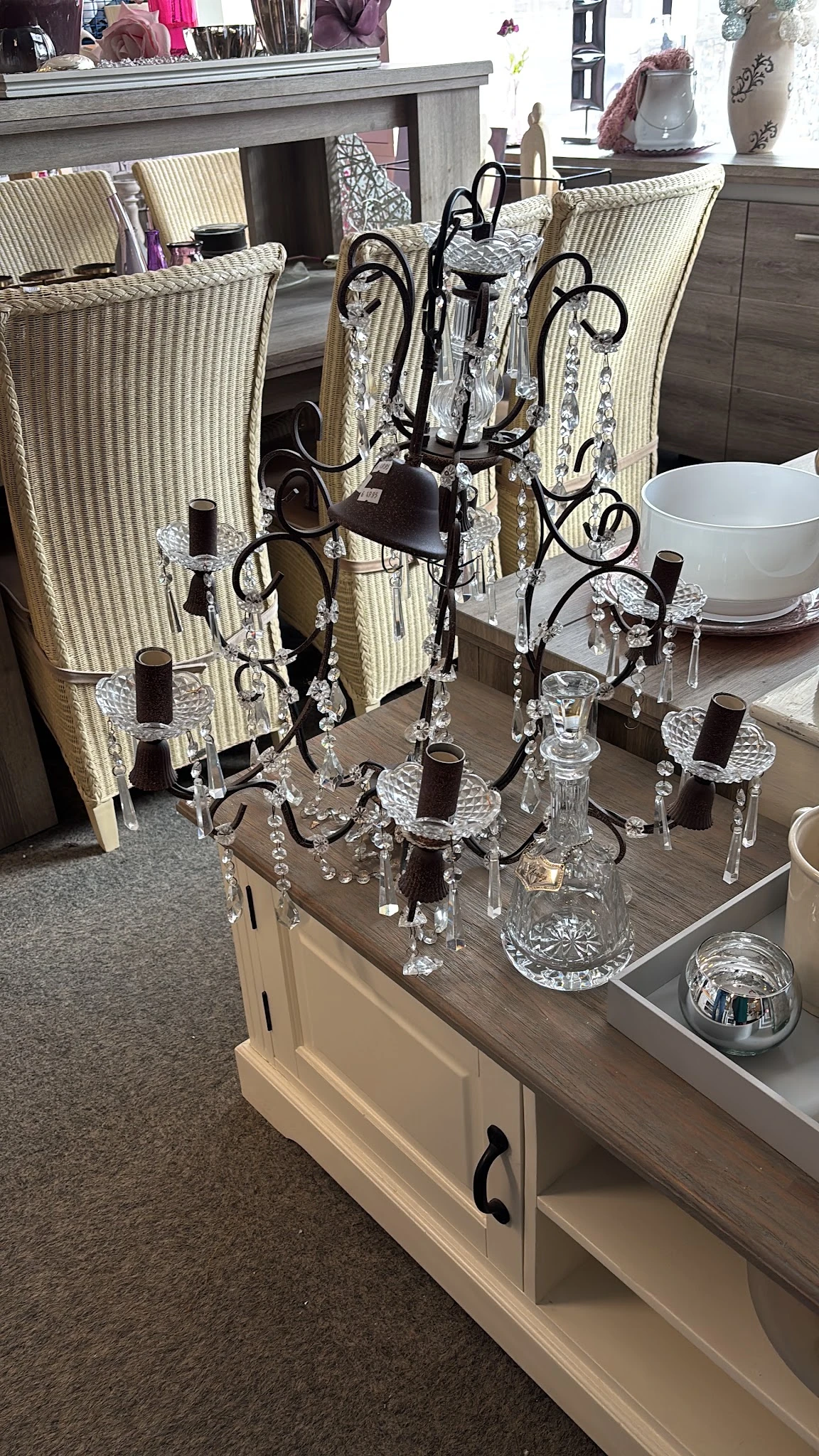 Kristallen kroonluchter met zwarte details en hangend kristal-ornamenten op houten tafel