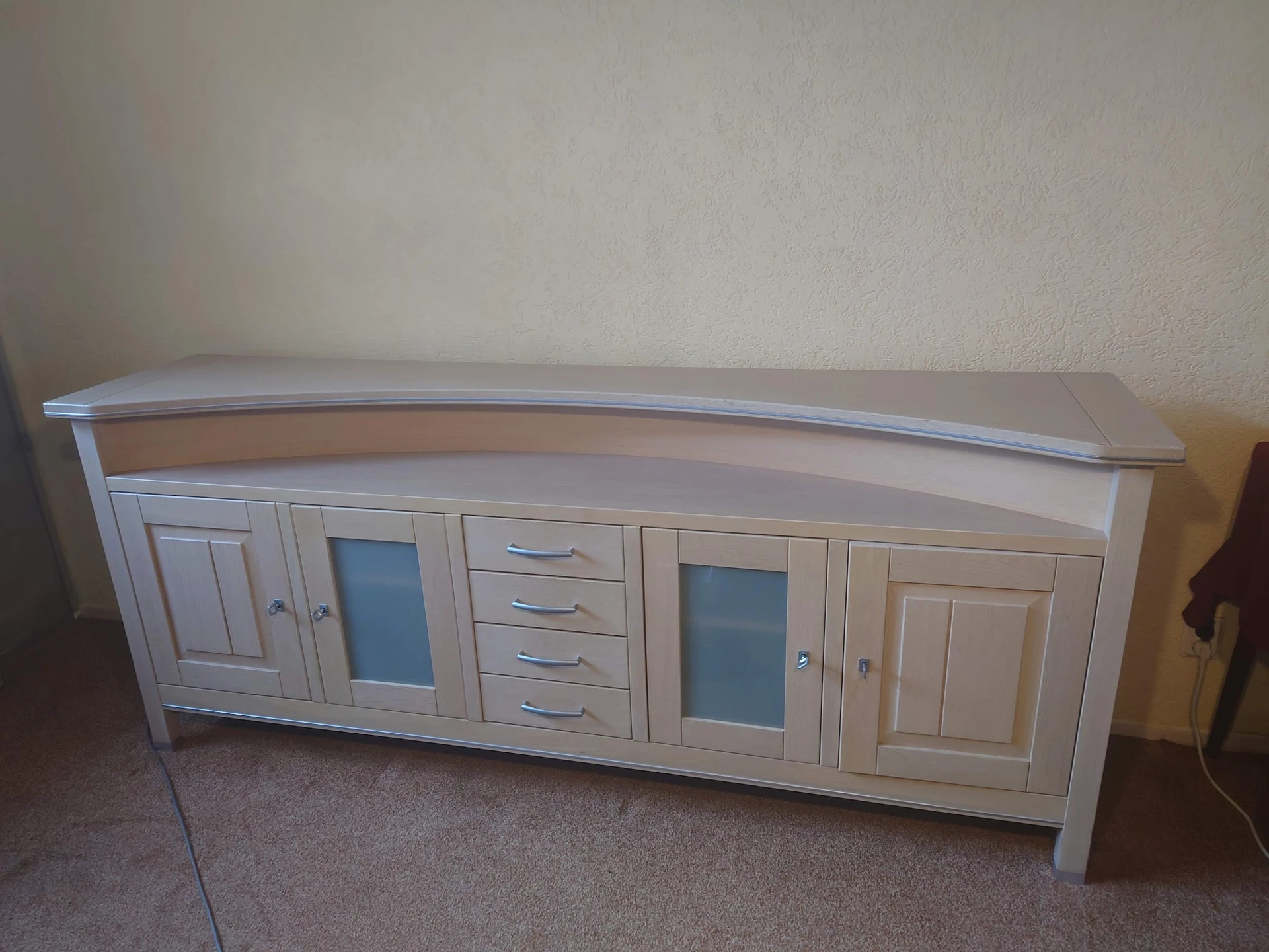 Wit dressoir met gebogen bovenkant, glazen deuren en laden
