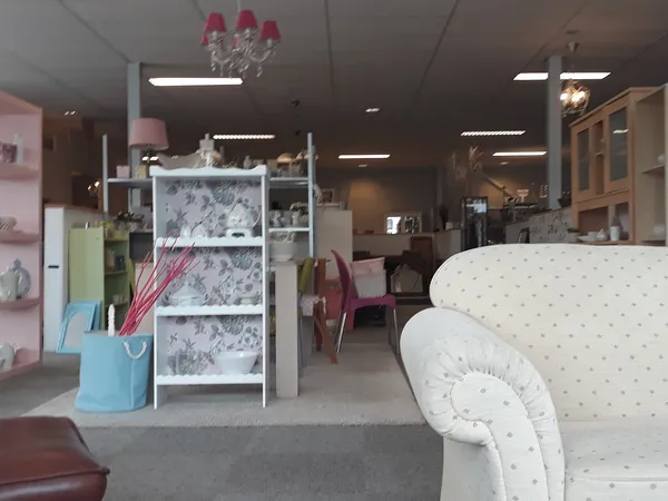 Winkelvloer met meubels, stellingen en huishoudartikelen in een kringloopwinkel