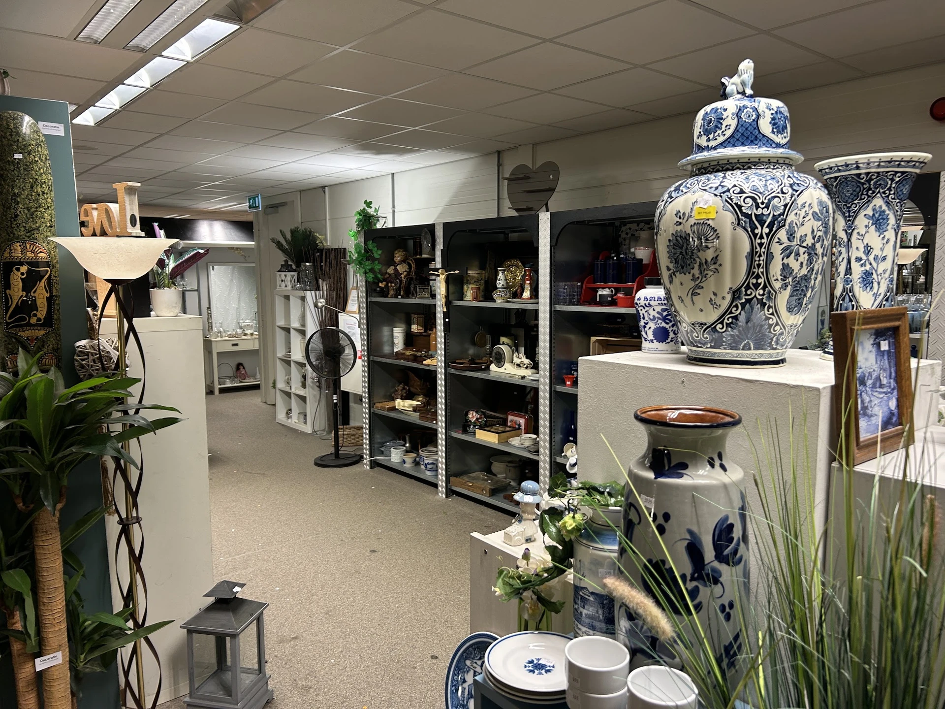 Winkelbinnenruimte met stellingen vol decoratieve items, keramiek en huisaccessoires