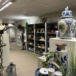 Winkelbinnenruimte met stellingen vol decoratieve items, keramiek en huisaccessoires
