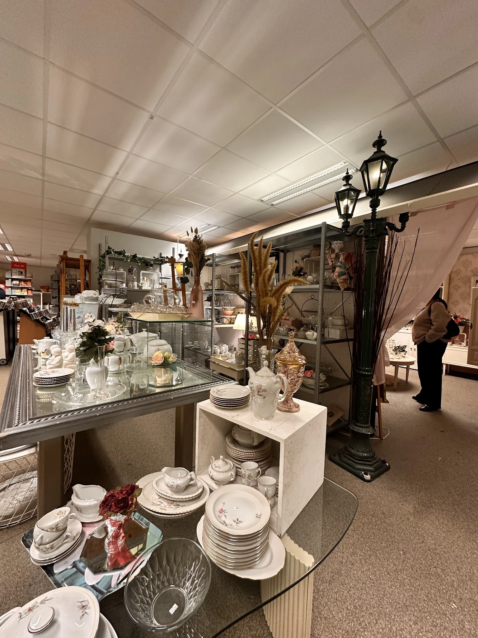 Winkelinterieur met glazen vitrines vol servies, decoratieve voorwerpen en accessoires
