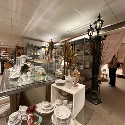 Winkelinterieur met glazen vitrines vol servies, decoratieve voorwerpen en accessoires