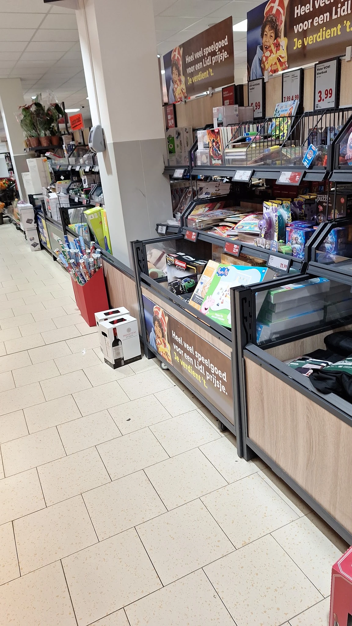 Winkelinterieur met toonbank, rekken met spullen en rode bak met artikelen op de vloer