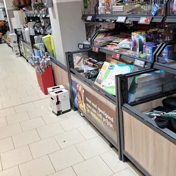Winkelinterieur met toonbank, rekken met spullen en rode bak met artikelen op de vloer