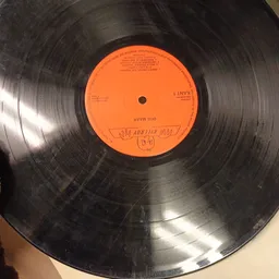 Close-up van een zwart vinyl record met oranje etiket