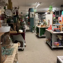 Winkelvloer met stellingen en rekken vol decoratieartikelen, bloemen, servies en huishoudelijke spullen