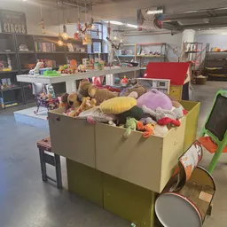 Grote gele box vol met knuffels, speelgoed en diverse huishoudelijke artikelen in de winkel