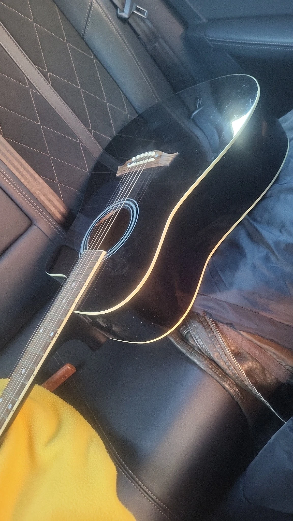 Zwarte akoestische gitaar met gouden inleggen, close-up van voorkant en zijkant