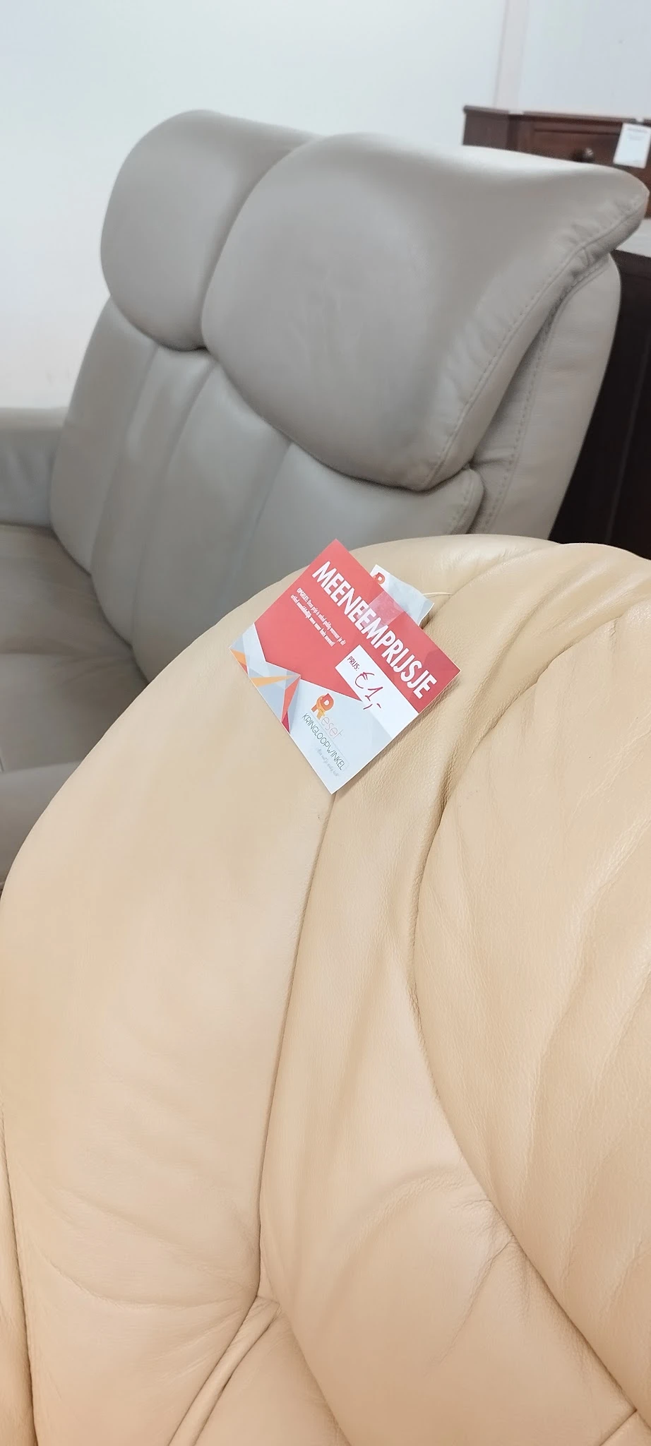 Tweedehands boek met roze kaft op een beige kussen