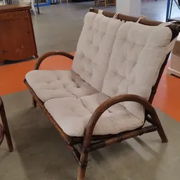 Houten fauteuil met witte gestoffeerde zitting en rugleuning op oranje vloer