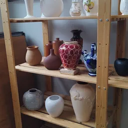 Houten stellingkast met decoratieve vazen en potten in verschillende kleuren en stijlen