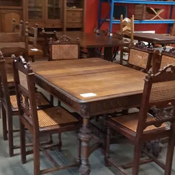 Houten eettafel met vier stoelen met rotan zitting in kringloopwinkel