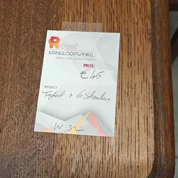 Handgeschreven prijskaartje met prijs €45 voor tafels en stoelen