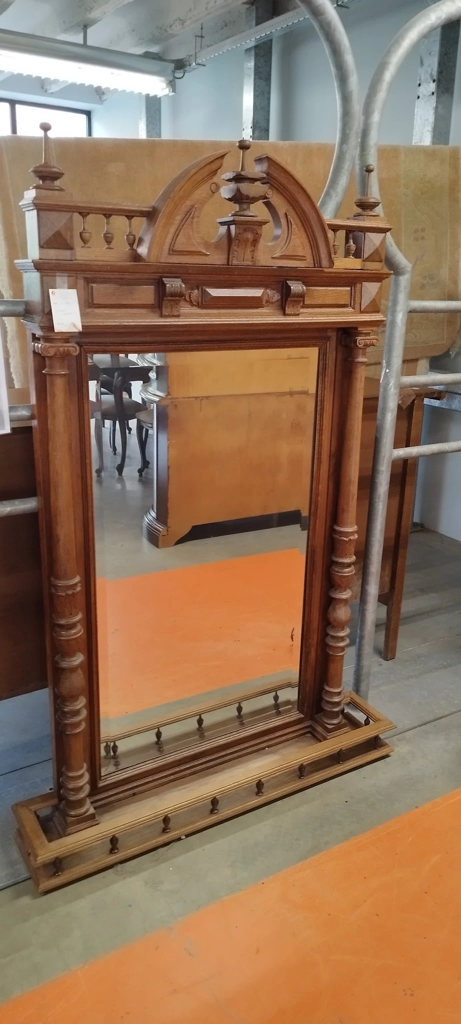Houten spiegellijst met bruine bewerking en oranje reflectie in de spiegel