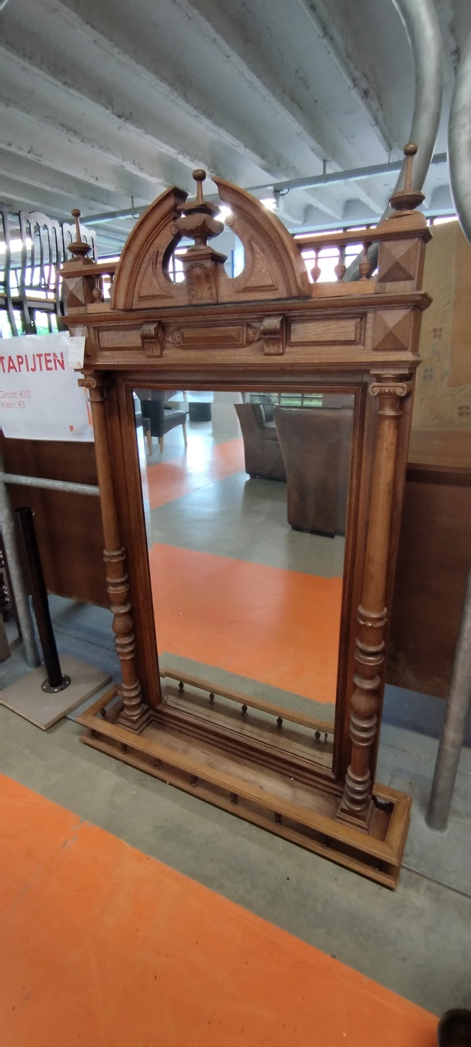 Houten vitrinekast met glazen deuren en gedraaide zuilen, gefotografeerd in winkelinterieur