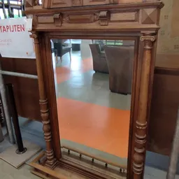 Houten vitrinekast met glazen deuren en gedraaide zuilen, gefotografeerd in winkelinterieur
