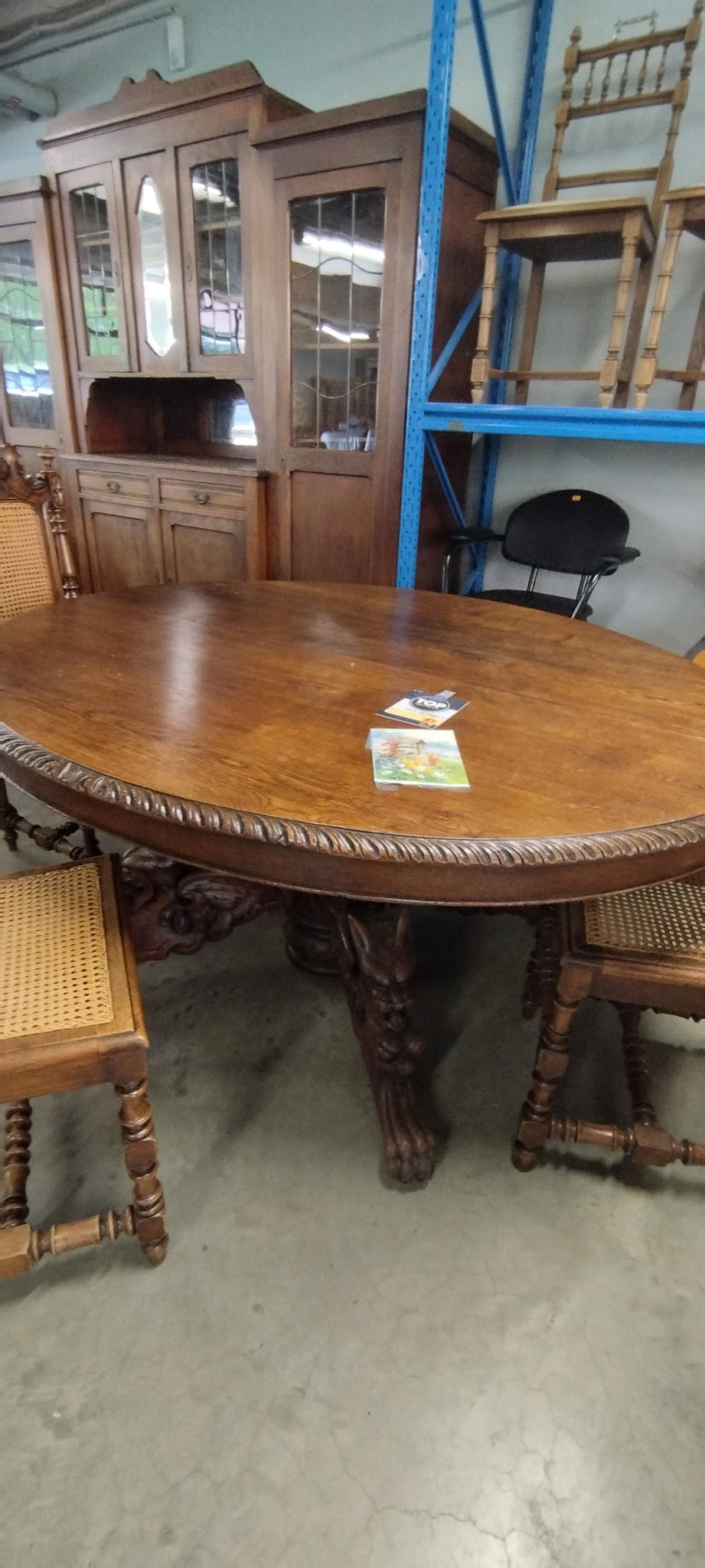 Ovale houten eettafel met uitgesneden rand en gedraaide poten, twee spellen op het tafelblad