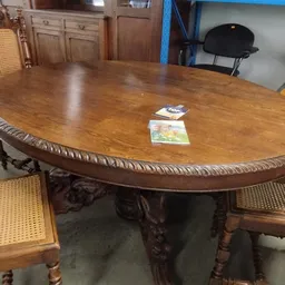 Ovale houten eettafel met uitgesneden rand en gedraaide poten, twee spellen op het tafelblad